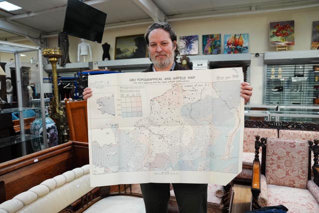 Medals & militaria specialist Matt Crowson holds maps contained within a rare top-secret blueprint of the D-Day landings
