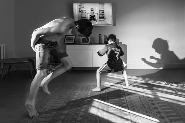 A photo issued by Historic England from its Picturing Lockdown Collection by Francesca Brecciaroli showing children taking part in the Joe Wicks PE sessions in the living room of their home in Beckenham, south London