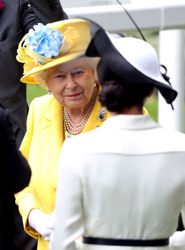 Queen Elizabeth II and the Duchess of Sussex during day one of Royal Ascot at Ascot Racecourse.
