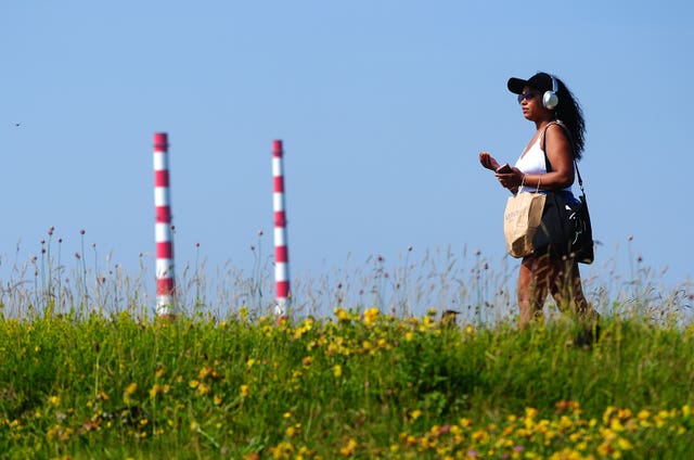 A person walks in the sunshine on Bull Wall in Dublin