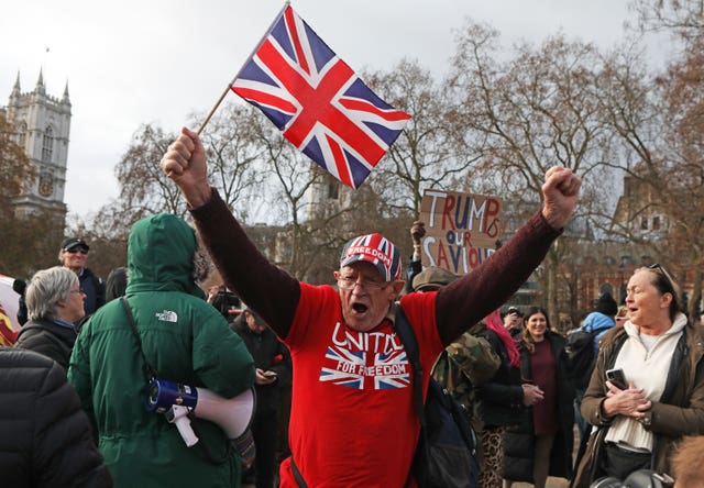 People take part in an anti-vaccination protest in Parliament Square, London