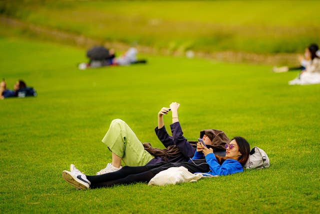 People sunbathe during warm weather