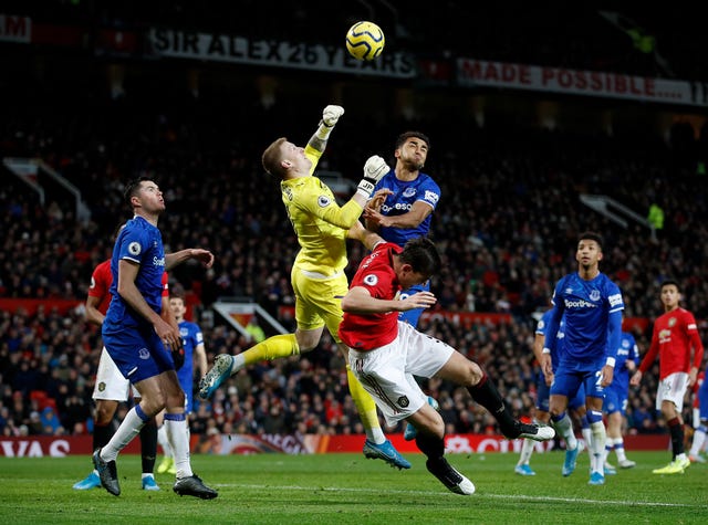 Everton goalkeeper Jordan Pickford punches the ball clear under pressure during their draw with Manchester United