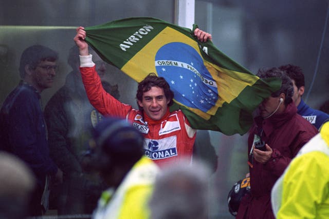 Senna flying the Brazilian flag as he works his way through the crowd to the winner's podium after victory in the European Grand Prix at Donington Park