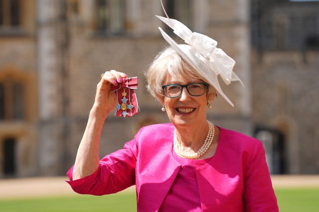 Patricia Hewitt in a bright pink dress and jacket with white hat