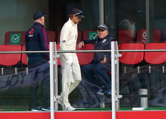 Joe Root, centre, speaks to Chris Silverwood, right