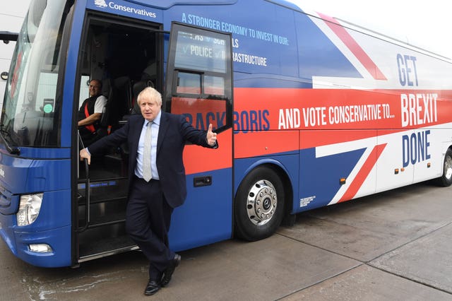 Boris Johnson by the Conservative Party battle bus in Middleton, Greater Manchester (Stefan Rousseau/PA)