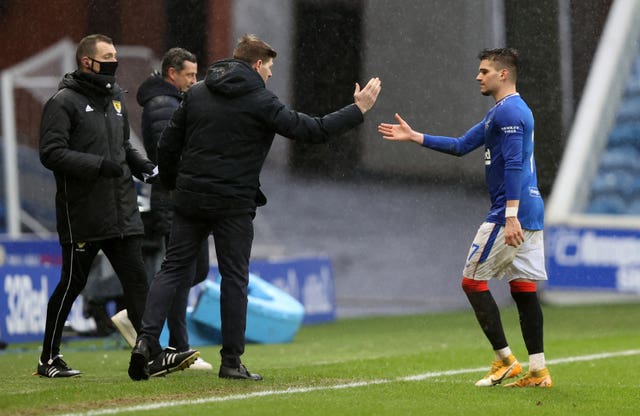 Hagi high-fives Rangers manager Steven Gerrard as he is substituted 