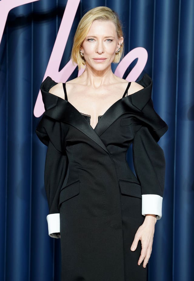 Cate Blanchett wearing an off the shoulder black gown with long sleeves and white cuffs