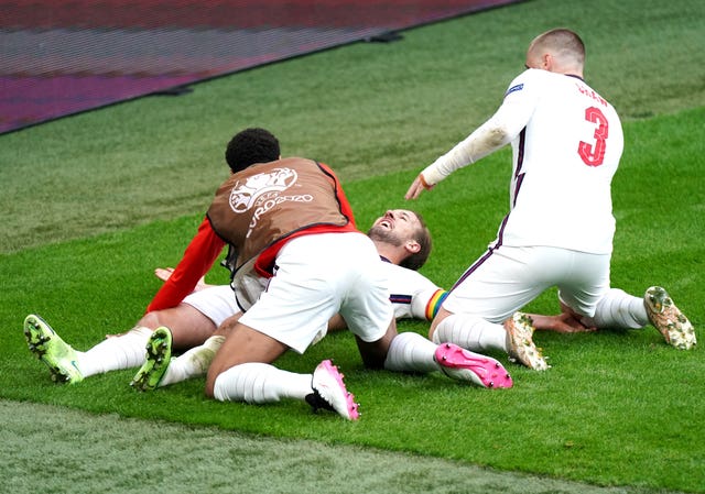 Kane is mobbed by his team-mates after heading his side into a 2-0 lead at Wembley