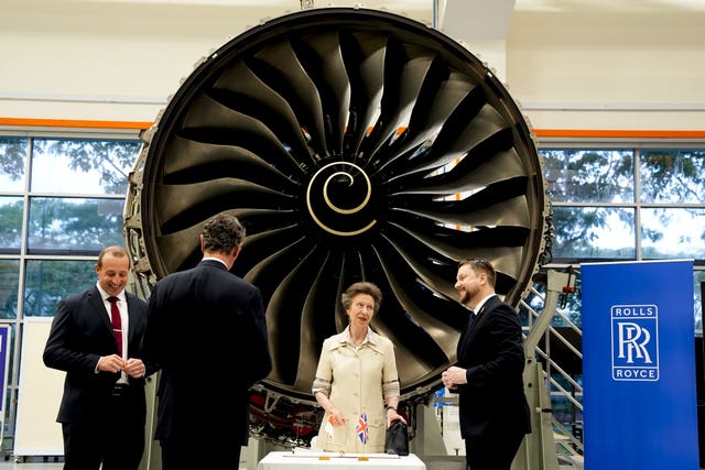 Princess Royal in front of an engine, alongside three men