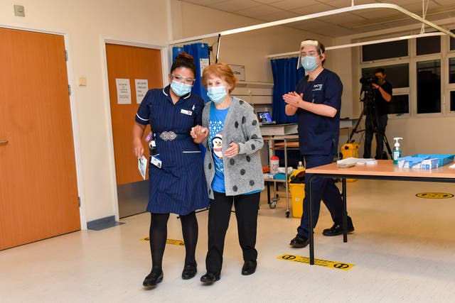 Margaret Keenan walks with nurse May Parson after becoming the first patient in the UK to receive the Pfizer/BioNTech Covid-19 vaccine at University Hospital Coventry