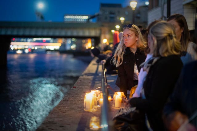 Mourners look out at the Thames after the the Bishop of Southwark held a short service