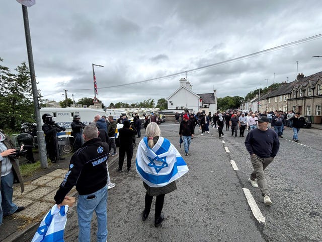 PSNI officers in riot gear with armoured vans separate counter protesters as the pro-Palestinian march from Lurgan to Newry passes through the village of Scarva