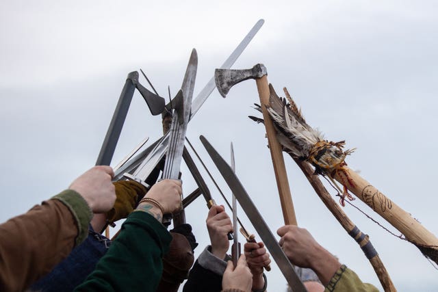 Re-enactors raise their weapons