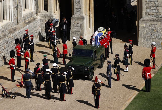 The Duke of Edinburgh’s coffin, covered with Personal Standard, is carried to the purpose-built Land Rover Defender ahead of his funeral at Windsor Castle, Berkshire