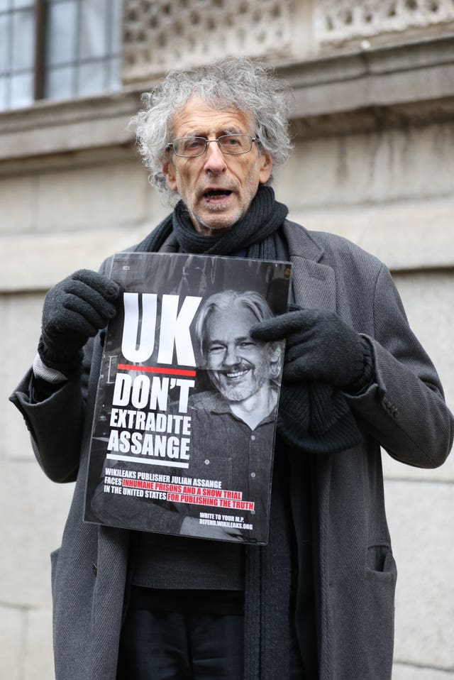 Piers Corbyn holds up a poster in support of Julian Assange outside the Old Bailey, London. 