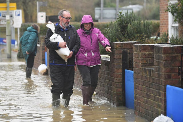 Residents of Gloucester Road in Tewkesbury collect sandbags to enforce their flood defences (Ben Birchall/PA).