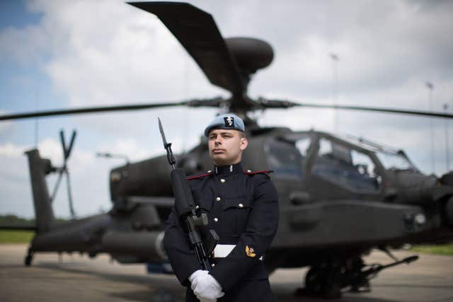 Craftsman Dekin, a Royal Electrical Engineer of 3 Regiment Army Air Corps in front of an Apache helicopter at Wattisham Airfield (Aaron Chown/PA)