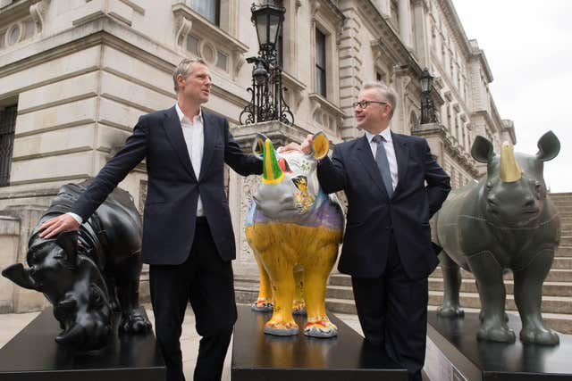 Zac Goldsmith, who is acting as champion of next month's Illegal Wildlife Trade Conference in London, joined Michael Gove to pose with the Tusk Trust rhino statues (Stefan Rousseau/PA) 