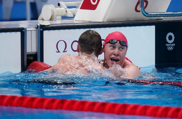 Tom Dean, right, hugs Duncan Scott after the race