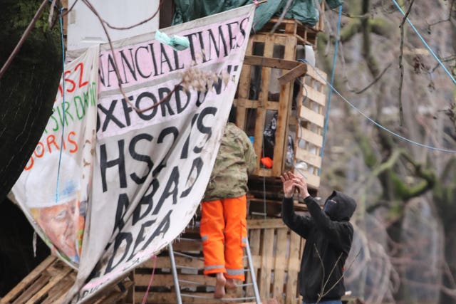 A HS2 protester catches a food parcel that has been given to him in trees at the encampment in Euston Square Gardens