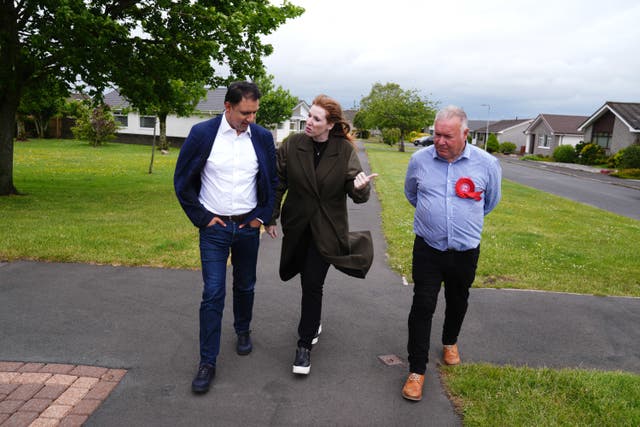 Angela Rayner walking along a pavement between Anas Sarwar and Davy Russell