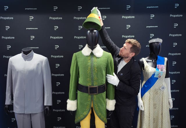 A Propstore employee adjusts the Elf costume