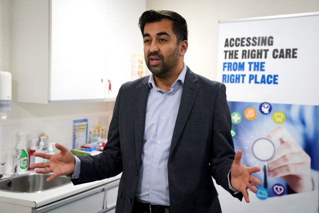 Health Secretary in front of an 'addressing the right care in the right place' sign