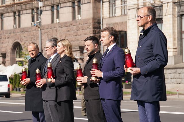 The leaders place candles at the memorial in Maidan Square