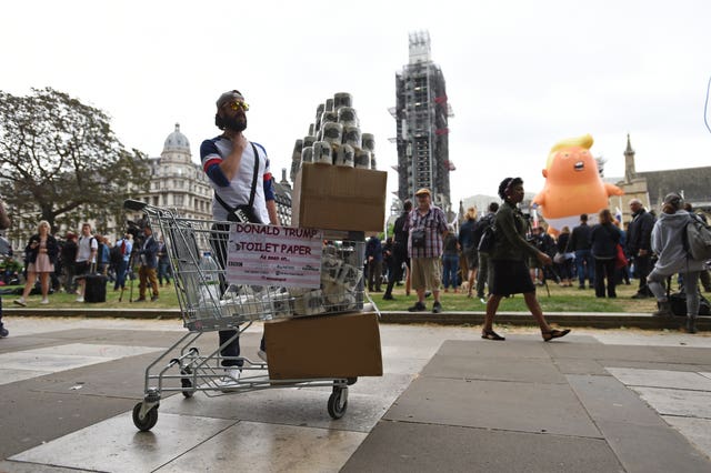 A man sells Donald Trump toilet paper by the Baby Trump Balloon during protests in Parliament Square