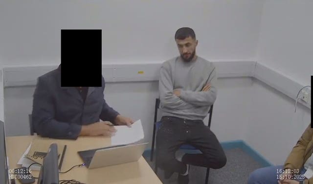 Abdulla Ahmadi being questioned by police officers
