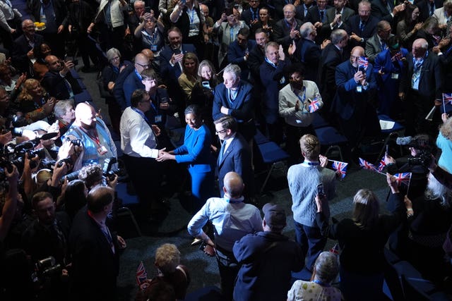 Kemi Badenoch shaking hands as she walks through a crowd at the Tory conference