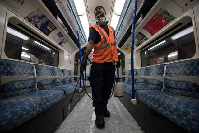 A TfL worker deep cleans a Victoria Line Tube train
