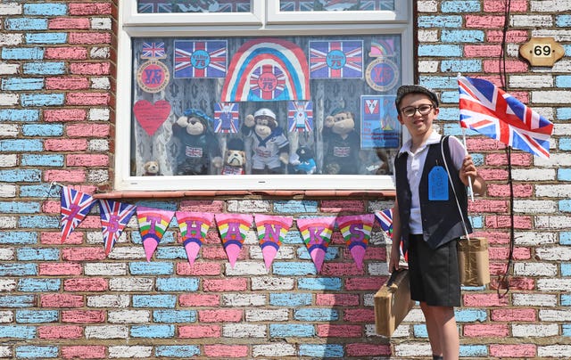 Alex Glover, 10, dressed as a Second World War evacuee outside his home in Sittingbourne, Kent, where he has created a VE Day theme which includes a tribute to 100-year-old Captain Tom Moore