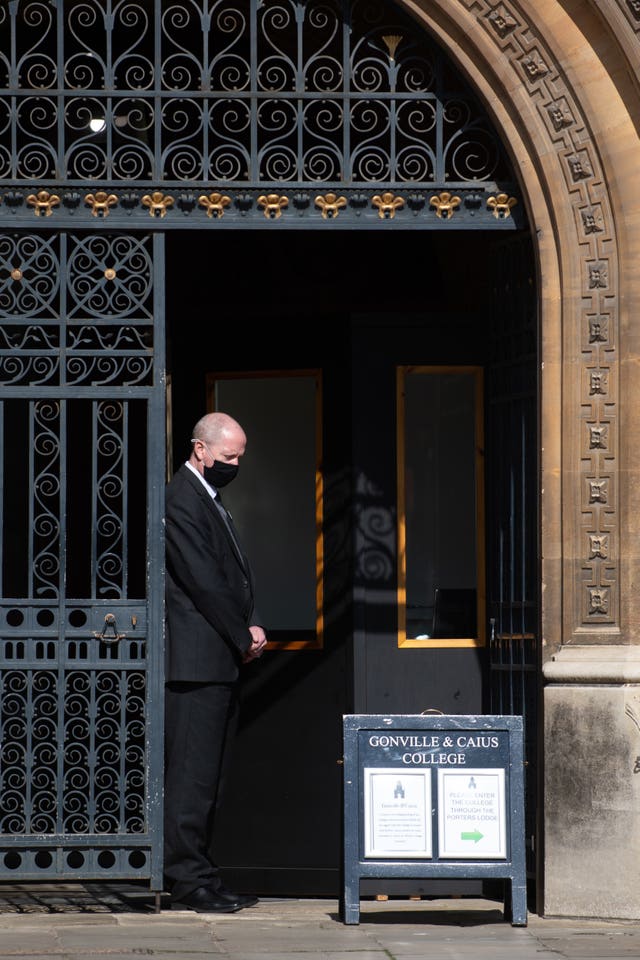 A porter observes a minute’s silence at a college in Cambridge