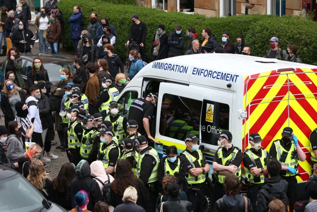 An immigration van in Kenmure Street, Glasgow, surrounded by protesters 