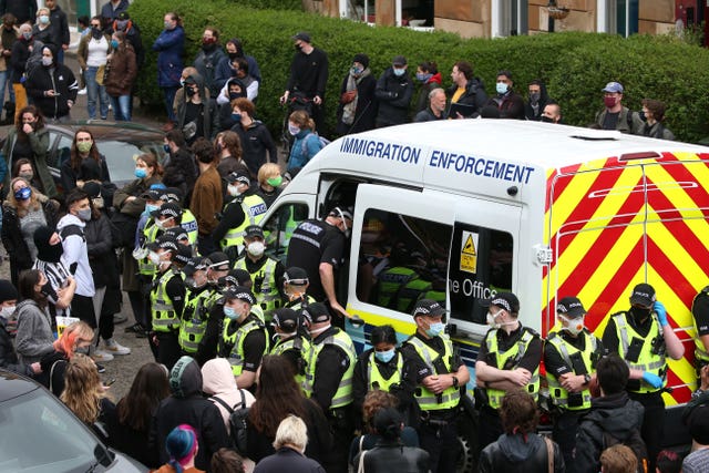 An immigration van in Kenmure Street, Glasgow, surrounded by protesters