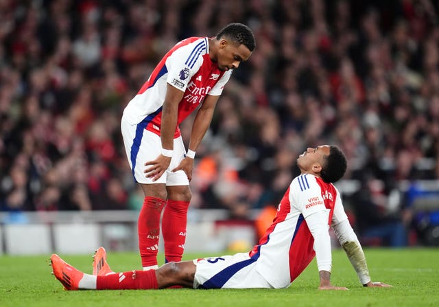 Gabriel sits on the ground, injured, when Jurrien Timber bends down to check on him.