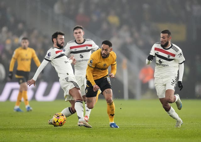 Wolverhampton Wanderers’ Matheus Cunha (centre) runs between Manchester United’s Bruno Fernandes (left) and Noussair Mazraoui