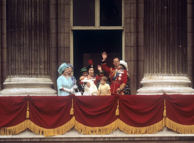 The Queen in uniform on the balcony of Buckingham Palace, holding 12-week-old son Prince Edward after the Trooping the Colour ceremony (PA)