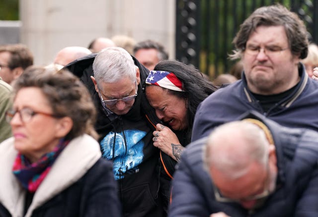 People on the Mall shed a tear and bow their heads as they listen to the state funeral of the Queen 