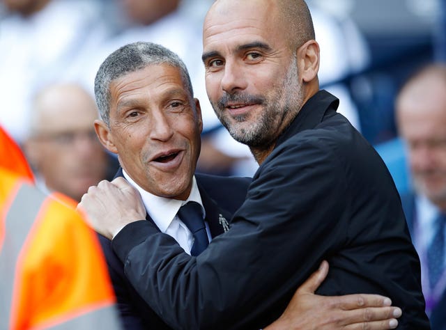 Chris Hughton shares an embrace with Pep Guardiola