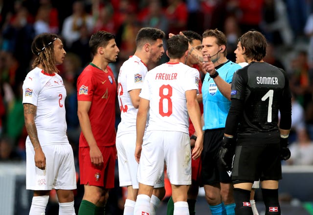 Referee Felix Brych (second right) took his time over a VAR check (PA)