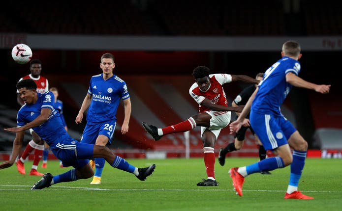 Bukayo Saka has a shot under pressure from multiple Leicester defenders