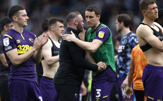 Wayne Rooney consoles his players following the defeat to QPR