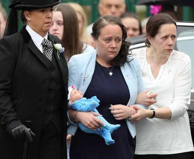 Mylee Billingham’s mother Tracey Taundry holds a doll as she arrives at the funeral (Aaron Chown/PA)