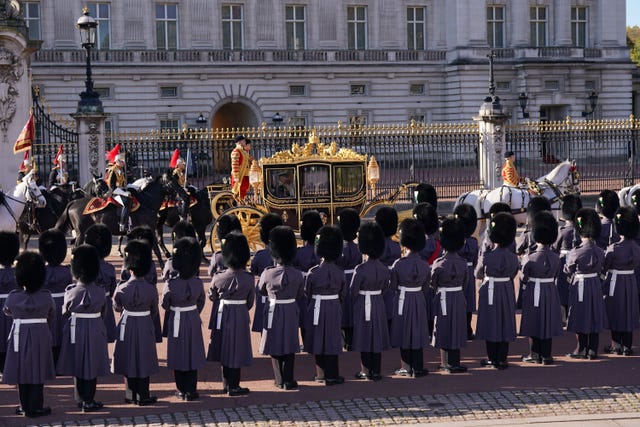 Troops in formation outside Buckingham Palace as the King and Queen leave in a state coach