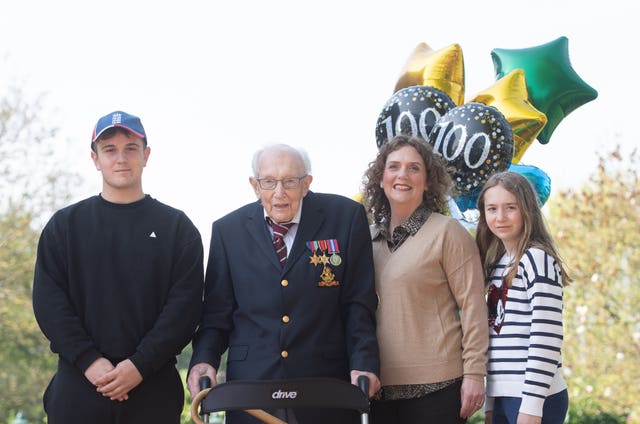 99-year-old war veteran Captain Tom Moore, with (left to right) grandson Benji, daughter Hannah Ingram-Moore and granddaughter Georgia, at his home in Marston Moretaine, Bedfordshire, after he achieved his goal of 100 laps of his garden – raising more than 14 million pounds for the NHS. Joe Giddens/PA Wire