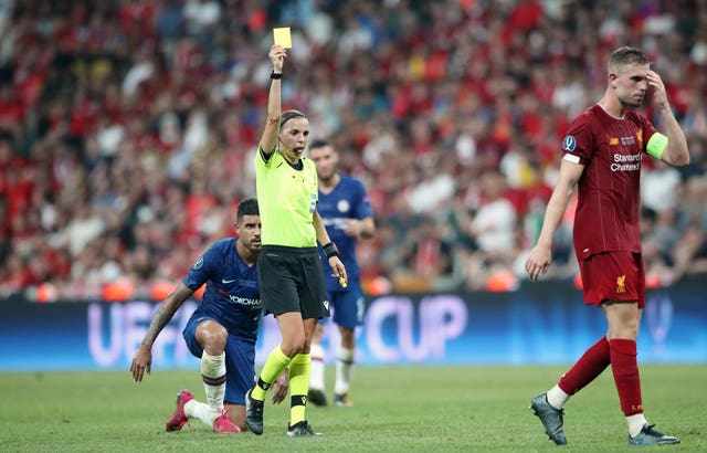 Referee Stephanie Frappart gives Liverpool’s Jordan Henderson a yellow card